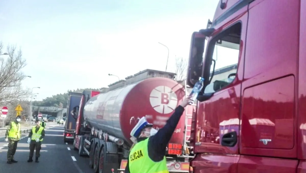 Policjanci pomagają w rozdawaniu posiłków i napojów na granicy